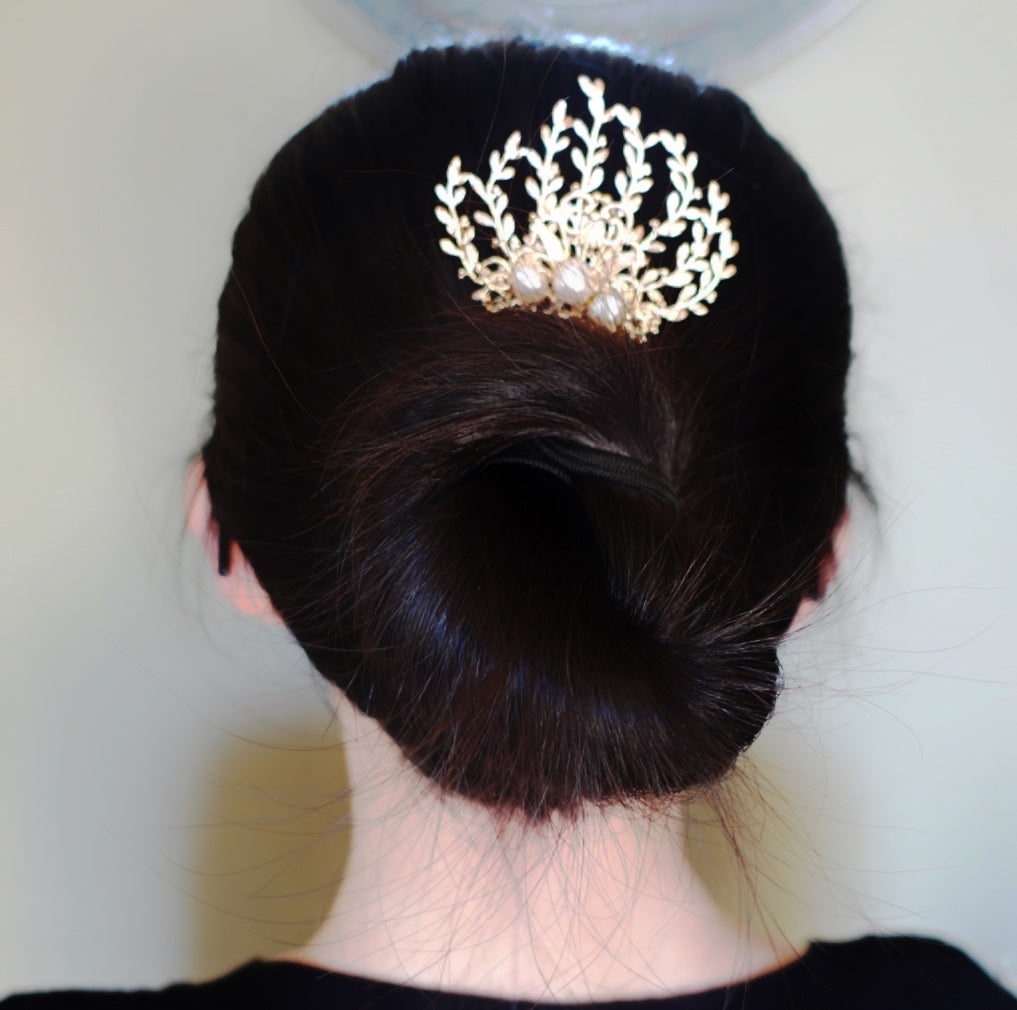 The Vine Hair Comb is a beautiful and versatile piece of jewelry that is perfect for adding a touch of elegance and whimsy to any outfit. The comb is gold plated and features baroque pearls, as well as solid wire wrap work that guarantees its reliable quality. The comb has the perfect size for holding the hair in place. The vine design of the comb is associated with elegance and the otherworldly beauty of elves and greek mythology.