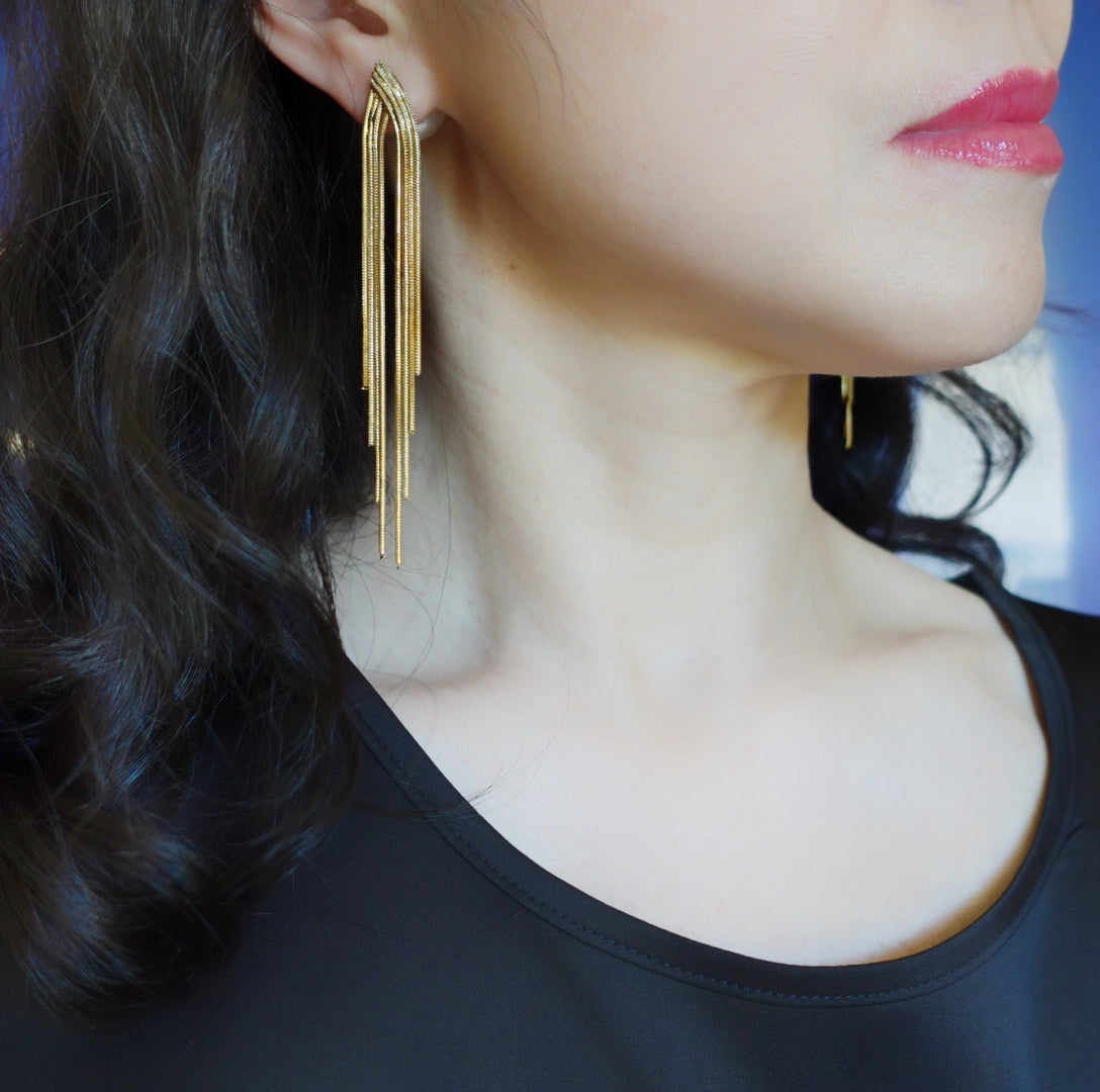 Enhance your style with Yun Boutique Tassel Stud Earrings. Features metal fringe adorned with faux pearl ear nut. Perfect for styling with modern and classic outfit for a chic and elegant look. 